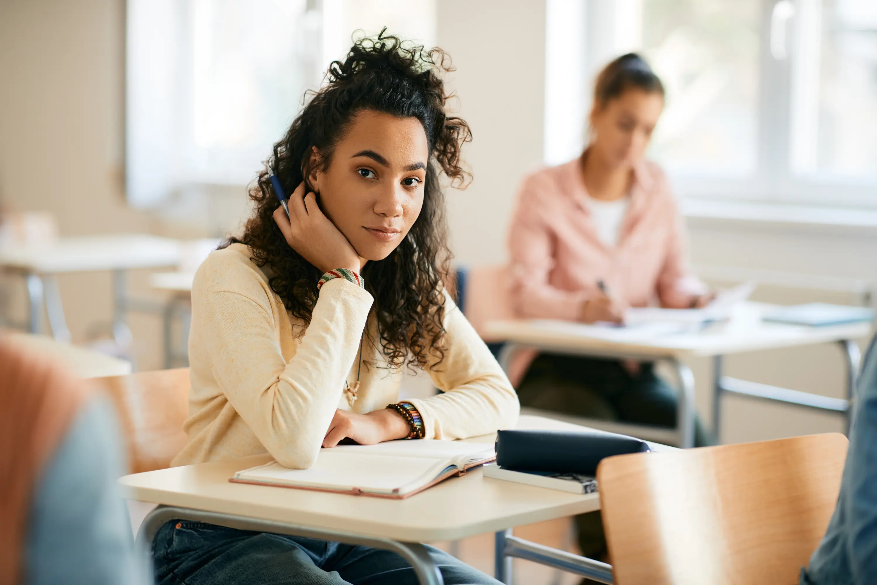 A young learner at her desk in a classroom