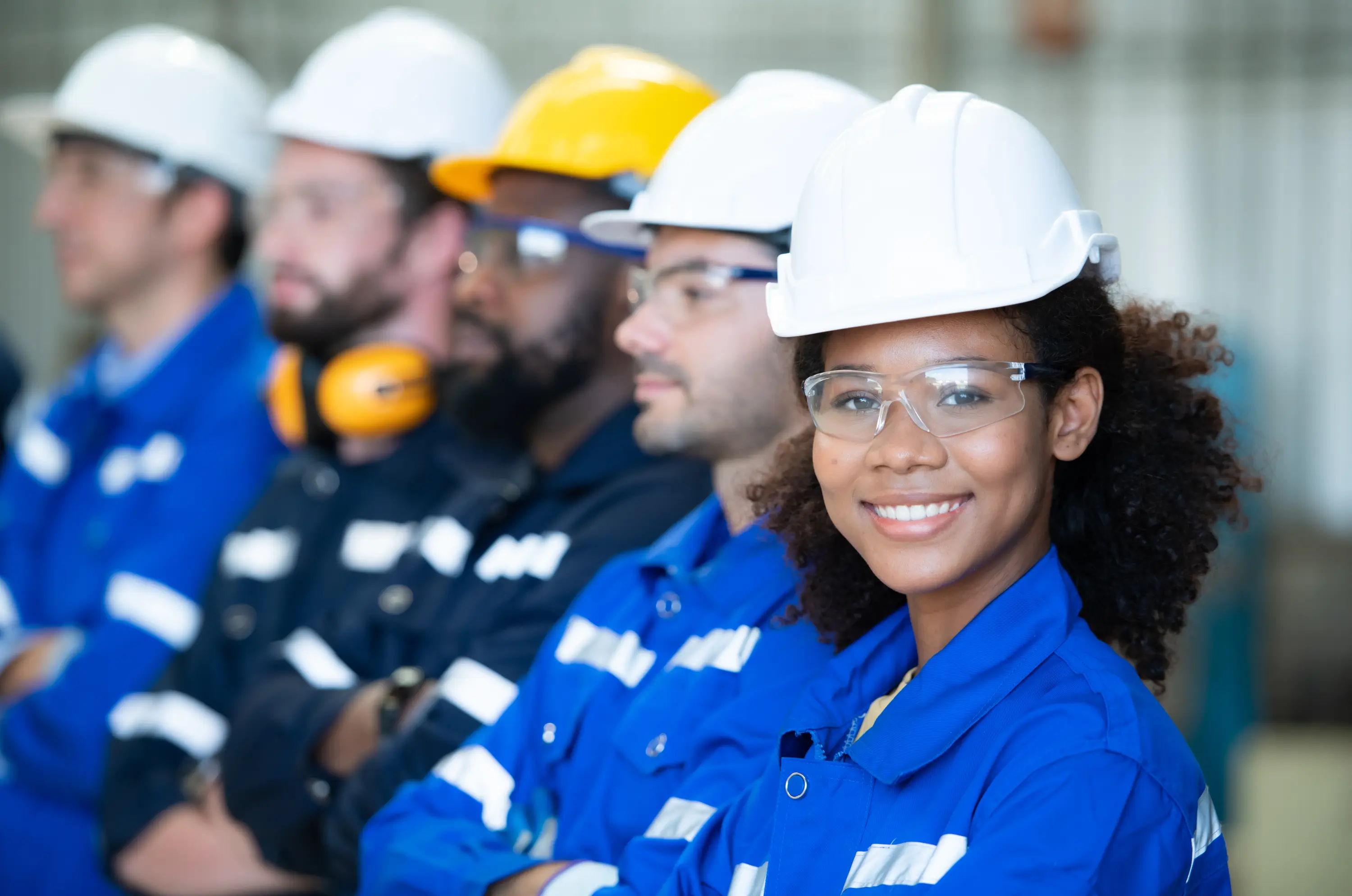 A young engineer in a hard hat with her team on site
